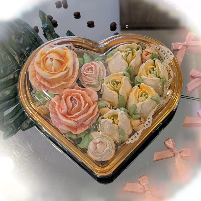 Clear heart-shaped box filled with handmade peach and cream marshmallow roses